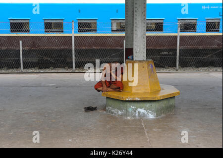 04.08.2013, Yangon, Repubblica dell' Unione di Myanmar, Asia - un monaco buddista è visto in appoggio alla piattaforma di Yangon la principale stazione ferroviaria. Foto Stock