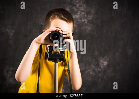 Giovane fotografo con la fotocamera su un treppiede pronta per scattare foto Foto Stock