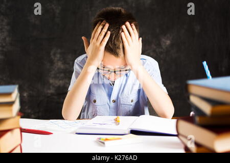 Ragazzo con problemi di finitura di studiare a casa Foto Stock