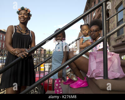 Famiglia su stoop a block party in Bedford Stuyvesant sezione di Brooklyn, NY, Aug.26, 2017. Foto Stock