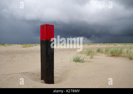 Polo di spiaggia su vasta spiaggia, nubi minacciose sopra il livello del mare Foto Stock