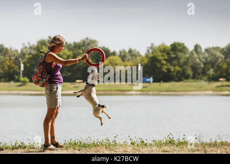 Donna che gioca con il cane sulla natura Foto Stock