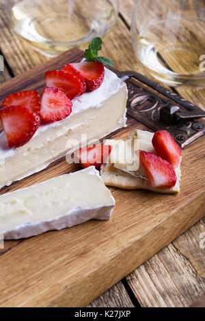 Vassoio di formaggi. Brie con fragole fresche e menta rustico di legno Foto Stock