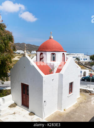 Piccola chiesa di bianco con un tetto rosso, Ano Mera, Mykonos, Grecia. Foto Stock