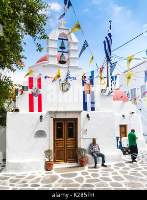 Piccola chiesa greco ortodossa con bunting e bandiere sul display, Mykonos, Greerce. Foto Stock