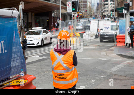 Signora ragazza che lavora come un controllore del traffico a Sydney CBD light rail project, tipicamente backpackers occupare questi posti di lavoro su una visa, Sydney, Australia Foto Stock