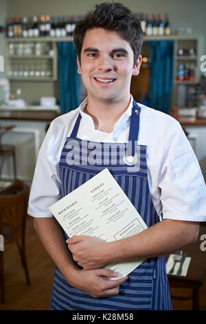 Ritratto di Chef in piedi nel ristorante Menu Azienda Foto Stock