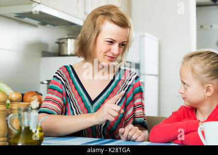 Sconvolto madre svergognare la figlia per comportamento scorretto in interni domestici Foto Stock