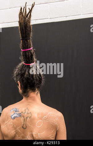 Un uomo con un unico acconciatura avente le spalle e la parte superiore della schiena dipinti alla Cornovaglia tattoo Concention Foto Stock