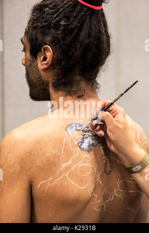 Body Painting - uomo avente il suo retro dipinto dal corpo di nicotina pittura presso la Cornovaglia Tattoo Convention. Foto Stock