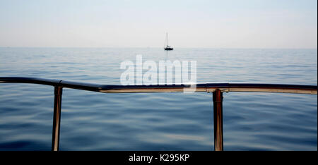 Naviga con la barca a vela nel tranquillo e caldo mare mediterraneo. L'orizzonte è davanti agli occhi. Foto Stock