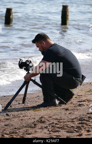 Fotografo in Teignmouth beach Devon impostazione apparecchiatura Foto Stock