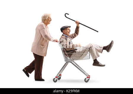 Donna anziana spingendo un carrello con un Senior in sella al suo interno isolato su sfondo bianco Foto Stock