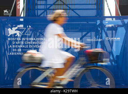 Venezia, Italia. Il 29 agosto, 2017. Una donna passa il messaggio pubblicitario della 74a Venice International Film Festival, a Venezia, Italia, il 29 agosto, 2017. 74a Mostra del Cinema di Venezia darà il via al Lido di Venezia il 30 agosto e si protrarranno fino sett. 9. Credito: Jin Yu/Xinhua/Alamy Live News Foto Stock