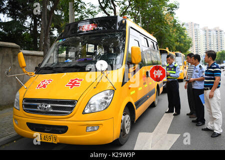 Hefei, cinese della provincia di Anhui. Il 29 agosto, 2017. Un poliziotto del traffico controlla una scuola bus a Hefei, a est della capitale cinese della provincia di Anhui, il 29 agosto 2017. La maggior parte degli studenti cinesi sta per ricevere il loro nuovo semestre a settembre. Credito: Xie Wenjun/Xinhua/Alamy Live News Foto Stock