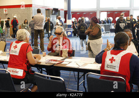 Houston, Stati Uniti d'America. Il 30 agosto, 2017. I membri della Croce Rossa di aiutare le persone a registrarsi presso la George Brown Convention Center che è stato aperto come un rifugio a Houston, Texas, gli Stati Uniti, il 30 agosto 2017. La Croce Rossa Americana stima che più di 17.000 Texans trascorso il lunedì notte in rifugi 45 aperta attraverso il membro di cui circa 9 mila persone presso il centro cittadino di Houston George Brown Convention Center. Credito: canzone Qiong/Xinhua/Alamy Live News Foto Stock