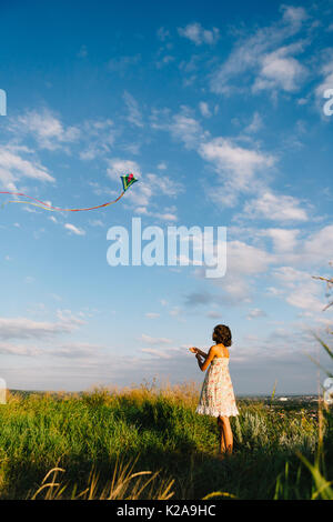 Ragazza che gioca con il kite in campo Foto Stock