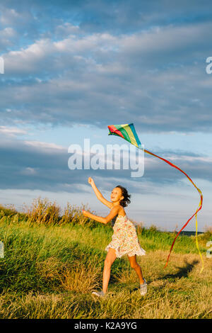 Allegro Ragazza che corre con kite Foto Stock