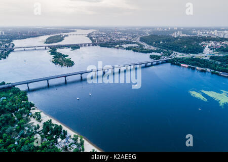 Vista panoramica della città di Kiev con il fiume Dnieper nel mezzo. Vista aerea del quartiere residenziale e la zona industriale al tramonto. Due banche di Foto Stock