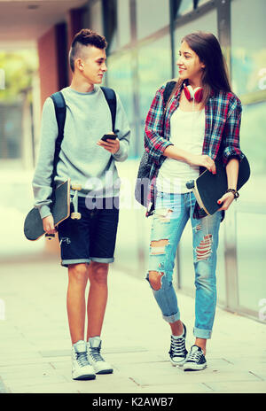 Ritratto di felice sorridente ragazza ragazzo e adolescenti con skateboard all'aperto Foto Stock