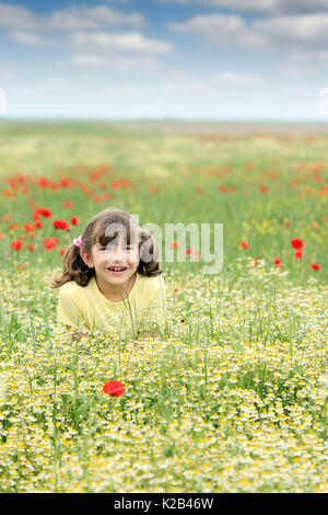 Felice bambina sul prato di fiori di campo stagione primavera Foto Stock