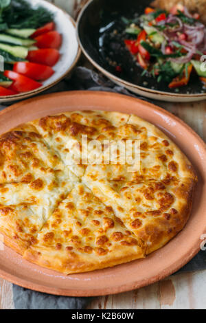 Tradizionale georgiano adjara khachapuri sul tavolo. In casa la cottura. khachapuri Kolkh e khachapuri al Imereti. Foto Stock