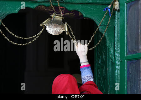 India. Il 29 agosto, 2017. Una donna del Kashmir detiene una icona religiosa catena e offre preghiere all'entrata del santuario di Shah e Hamdan sulla morte anniversario dello studioso sufi Mir Syed Ali Hamadani a Srinagar, controllata indiano Kashmir, martedì 29 agosto 2017 centinaia di Kashmiris ha visitato il santuario di Hamadani, che è nato in Iran, Kashmir ha visitato diverse volte e ha giocato un ruolo influente nella diffusione dell Islam in valle. Credito: Umer Asif/Pacific Press/Alamy Live News Foto Stock