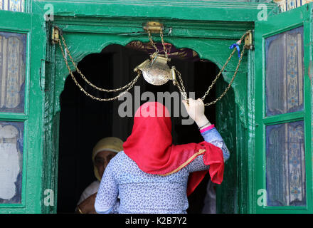India. Il 29 agosto, 2017. Una donna del Kashmir detiene una icona religiosa catena e offre preghiere all'entrata del santuario di Shah e Hamdan sulla morte anniversario dello studioso sufi Mir Syed Ali Hamadani a Srinagar, controllata indiano Kashmir, martedì 29 agosto 2017 centinaia di Kashmiris ha visitato il santuario di Hamadani, che è nato in Iran, Kashmir ha visitato diverse volte e ha giocato un ruolo influente nella diffusione dell Islam in valle. Credito: Umer Asif/Pacific Press/Alamy Live News Foto Stock