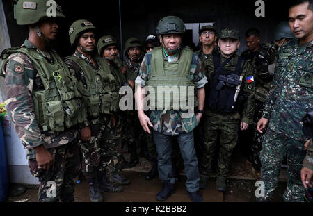 Il presidente filippino Rodrigo Duterte indossando piena battaglia visite marcia soldati linee anteriore combattere i terroristi islamici Agosto 24, 2017 in Marawi City, Filippine. Le forze armate delle Filippine stanno combattendo ISIS fighters in Malawi città e sono state combattendo locale i ribelli islamici nella provincia di Mindanao per decenni. Foto Stock