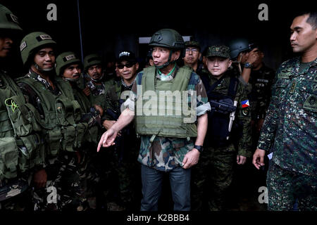 Il presidente filippino Rodrigo Duterte indossando piena battaglia visite marcia soldati linee anteriore combattere i terroristi islamici Agosto 24, 2017 in Marawi City, Filippine. Le forze armate delle Filippine stanno combattendo ISIS fighters in Malawi città e sono state combattendo locale i ribelli islamici nella provincia di Mindanao per decenni. Foto Stock