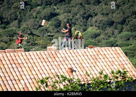 Conciatetti lavorando su tassellatura del tetto di una nuova casa in costruzione sulla Costa Azzurra nel sud della Francia Foto Stock