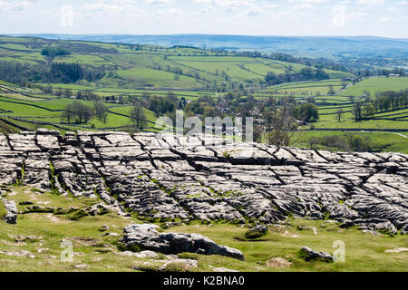 E Clints grikes in calcare pavimentazione in cima Malham Cove con borgo oltre. Malham Yorkshire Dales National Park England Regno Unito Foto Stock