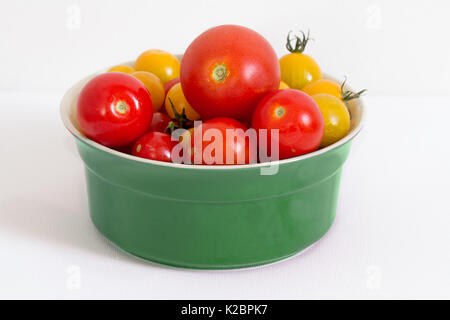 I pomodori in un recipiente isolato su bianco Foto Stock