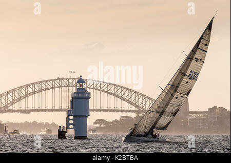 Sailing yacht passato un faro nella parte anteriore del Ponte del Porto di Sydney, Nuovo Galles del Sud, Australia, novembre 2012. Tutti i non-usi editoriali deve essere eliminato singolarmente. Foto Stock