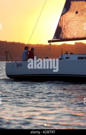 Giovane su J/111 yacht a vela in Narragansett Bay al tramonto. La Rhode Island, STATI UNITI D'AMERICA, Agosto 2010. Foto Stock