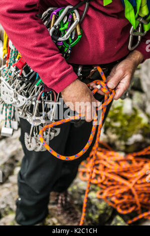 Un ritratto di un uomo maturo la predisposizione di se stesso per andare scalata su roccia. Foto Stock