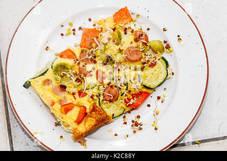 Bella Frittata con salsiccia tagliata a fettine, pomodorini e rucola in  padella sul tavolo di legno con carta asciugatutto, vista da sopra Foto  stock - Alamy