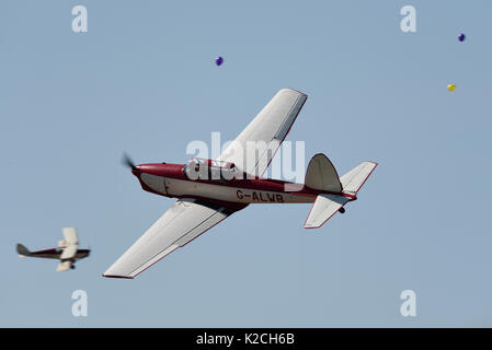 DHC Scoiattolo striado volando attraverso palloncini a poco Gransden bambini bisognosi di airshow. Pilot Dennis Neville. Capitano Neville Flying Circus Foto Stock