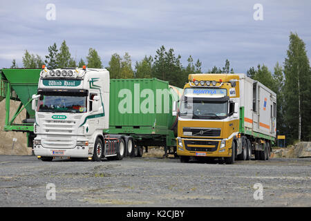 FORSSA, Finlandia - 25 agosto 2017: Bianco autocarro Scania di vento raggio giallo e Volvo FH di Mantyla fornire un carico sul sito industriale. Foto Stock