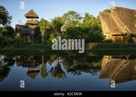 Giugno 6, 2017 Puerto Misahualli: eco lodge costruito da bambù nella giungla riflettendo nper acqua al tramonto Foto Stock