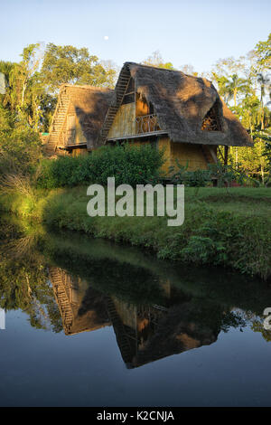 Giugno 6, 2017 Puerto Misahualli: eco lodge costruito da bambù nella giungla riflettendo nper acqua al tramonto Foto Stock