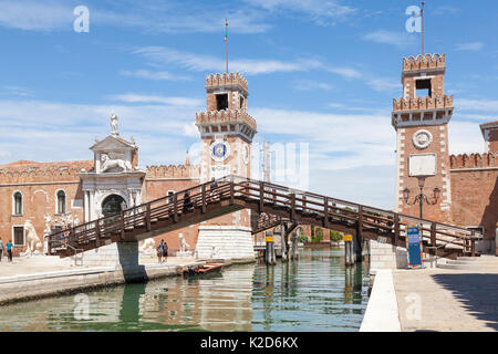 Due turisti in piedi sul Ponte del l' Arsenal o del Paradiso ammirando l'ingresso dell'Arsenale di Venezia con riflessioni sul Rio de l'Ars Foto Stock