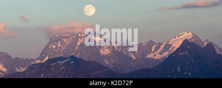 Full Moon Rising oltre l'Watzespitze (3554m), parte dell'Glockturmkamm, la cresta occidentale delle Alpi Otztal. Nordtirol, Alpi austriache. Luglio. Cucito digitalmente panorama. Foto Stock
