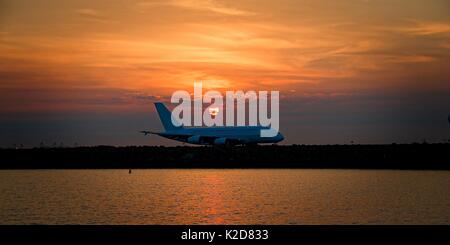 Aviogetti civili, al tramonto, il rullaggio in su asfalto a Sir Kingsford Smith Airport, mascotte, Sydney, Australia. Foto Stock