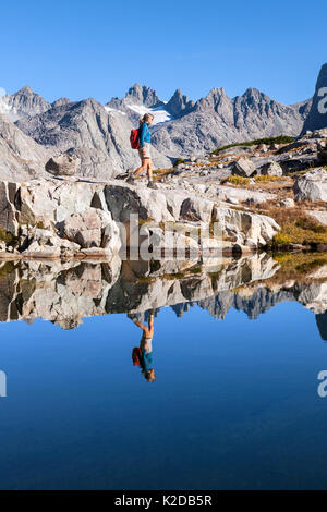 Escursionista esplorare il lago di montagna nel bacino Titcomb, Wind River Range, Bridger deserto, Bridger National Forest, Wyoming negli Stati Uniti. Settembre 2015. Modello rilasciato. Foto Stock