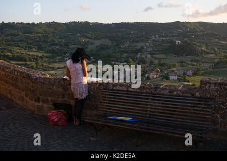 Una femmina di pittore, pittura di Orvieto la campagna al tramonto da uno dei Orieto hill punti panoramici. La pittura di paesaggio, ispirazione dalla natura Foto Stock
