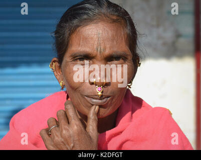 La donna indiana degli anziani Adivasi (tribù Desia Kondh, tribù Kovi Kondh) con gioielli al naso in oro e gemme e orecchini tribali sorride per la macchina fotografica. Foto Stock