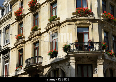 Giovane donna avente la colazione sul balcone, Tabora, il centro città di Bruxelles, in Belgio Foto Stock