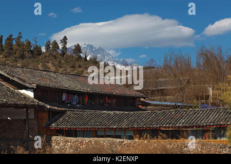 Case nel villaggio vicino lago Lashihai con montagna in background, Lijiang, nella provincia dello Yunnan in Cina. Gennaio 2012 Foto Stock