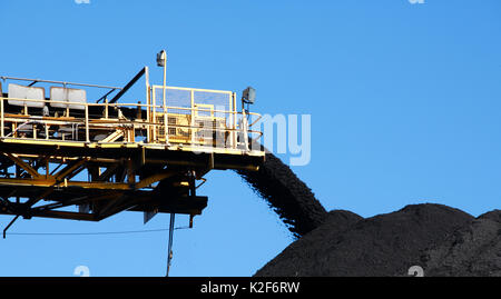 Il giallo del carbone nastro trasportatore che trasportano carbone e versare su un palo, Australia Foto Stock